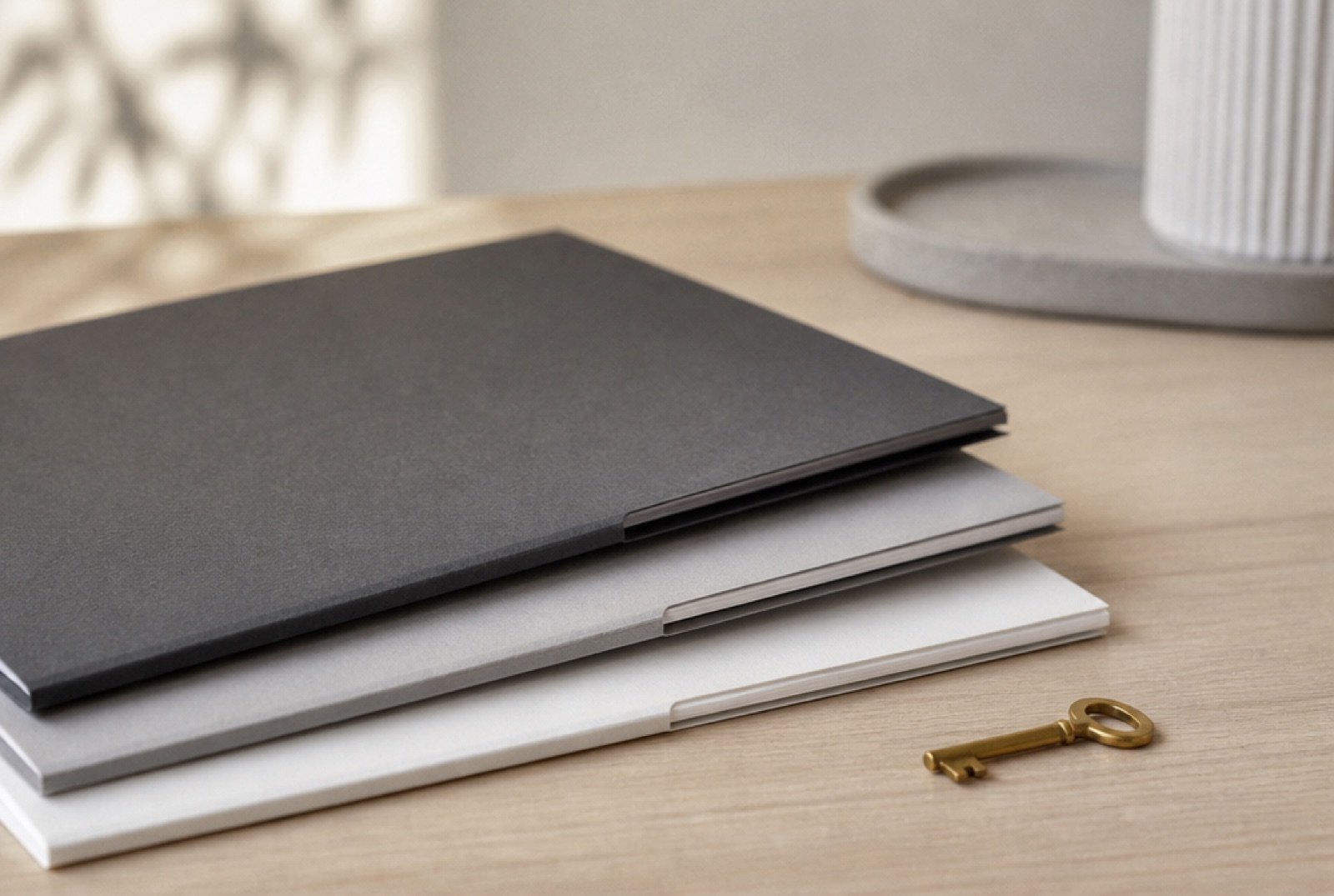 Three document folders stacked in steps beside a small key